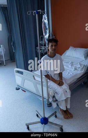 Weibliche Patienten sitzen auf dem Bett im Krankenhaus Stockfoto