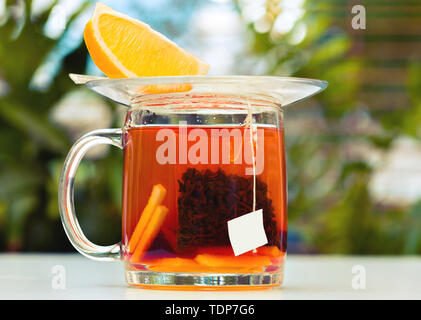 Schwarzer Tee mit einer Scheibe Zitrone in einem Glas mug Stockfoto