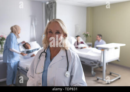 Ärztin lächelnd auf der Station im Krankenhaus Stockfoto