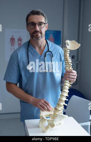 Männliche orthopädischer Chirurg holding Wirbelsäule Modell im Krankenhaus Stockfoto