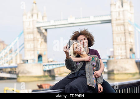 Glückliches Paar unter selfie Foto an der Tower Bridge Stockfoto