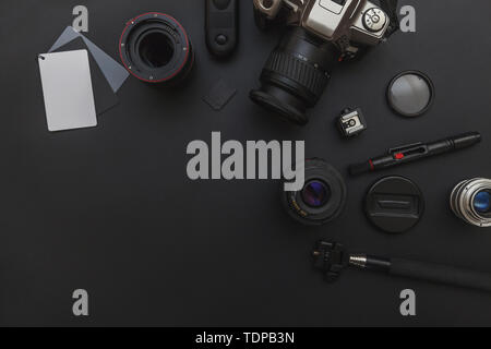 Fotograf Arbeitsplatz mit DSLR-Kamera System, Kamera Reinigungsset, Kamera und Zubehör auf dunklen schwarzen Tisch Hintergrund. Hobby reisen Foto Stockfoto
