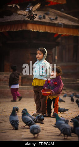 Kinder füttern Tauben in Duba Square, Kathmandu, Nepal Stockfoto