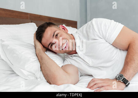 Jungen gutaussehenden Mann auf dem Bett entspannen nach einem harten Tag an der Arbeit Stockfoto