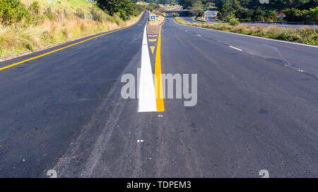 Straße Autobahn neue Asphalt Asphalt weiß lackiert gelbe Markierungen Ausfahrt richtungen Linien Nahaufnahme Mitte overhead Foto detail. Stockfoto