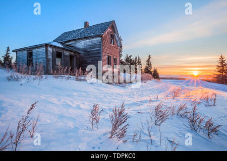 Verfallene Bauernhaus bei Sonnenaufgang im Winter, in der Nähe von Winnipeg, Manitoba, Kanada Stockfoto