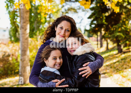 Eine Mutter und ihre zwei Töchter für eine Familie Portrait of a city Park an einem warmen Herbst Tag posieren; Edmonton, Alberta, Kanada Stockfoto