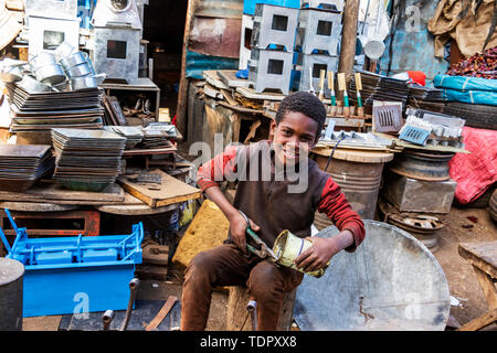 Eritreische junge schneiden kann am Medeber Markt, wo Handwerker alte Reifen und Dosen neue Artefakte zu recyceln, Asmara, Eritrea Stockfoto