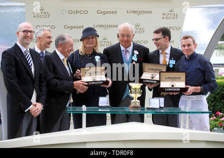 Matthieu Baumgartner (links) stellt Jockey Ryan Moore (rechts), Trainer A P O'Brien (Zweiter von rechts), Inhaber John magnier (3. rechts) und gewinnende Verbindungen von Arizona mit der Trophäe, nachdem er die Coventry Stakes während der Tag des Royal Ascot Hotel in Ascot Pferderennbahn. Stockfoto