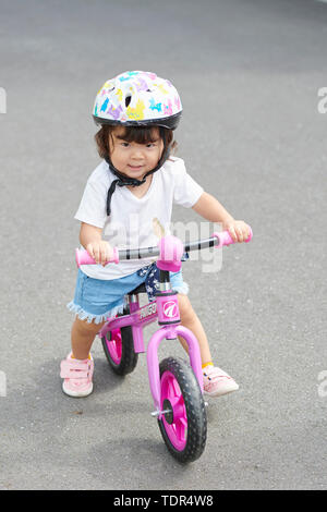 Japanisches Kind auf einem Fahrrad Stockfoto