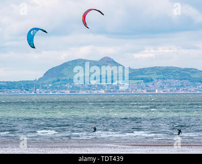 Longniddry Bents, Erhabene, Schottland, Vereinigtes Königreich, 18. Juni 2019. UK Wetter: Kite Surfer haben ideale Bedingungen bei Ebbe mit einem starken Wind und Sonnenschein in der abgehackt Firth von weiter in Richtung die unverwechselbare Skyline von Edinburgh über die Bucht auf der Suche Stockfoto