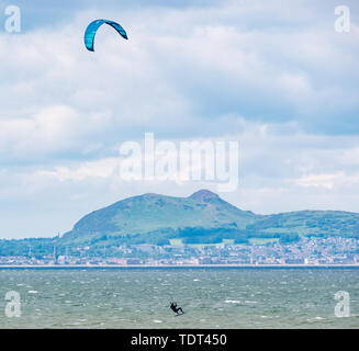 Longniddry Bents, Erhabene, Schottland, Vereinigtes Königreich, 18. Juni 2019. UK Wetter: Kite Surfer haben ideale Bedingungen bei Ebbe mit einem starken Wind und Sonnenschein in der abgehackt Firth von weiter in Richtung die unverwechselbare Skyline von Edinburgh über die Bucht auf der Suche Stockfoto