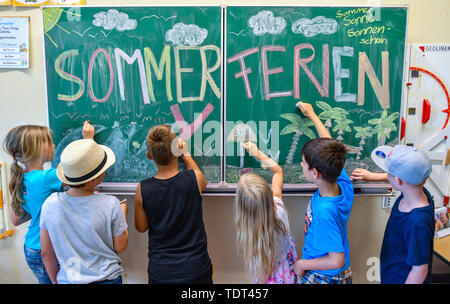 18. Juni 2019, Brandenburg, Booßen: Illustration: Die Schülerinnen und Schüler (L-R) Nele, Ben, Meier, Johanna, Domenik und Arijen aus der Klasse 2 A der Grundschule "Am Mühlenfließ" Farbe in ihrem Klassenzimmer auf einer Tafel mit der Inschrift ommerferien' (Bild). Am 19.06.2019 ist der letzte Schultag in Berlin und Brandenburg. Die Sommerferien laufen von 20. Juni bis 02. August 2019. Foto: Patrick Pleul/dpa-Zentralbild/ZB Stockfoto