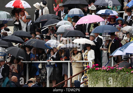 Massen von racegoers Sonnenschirme halten während der Tag zwei des Royal Ascot Hotel in Ascot Pferderennbahn. Stockfoto