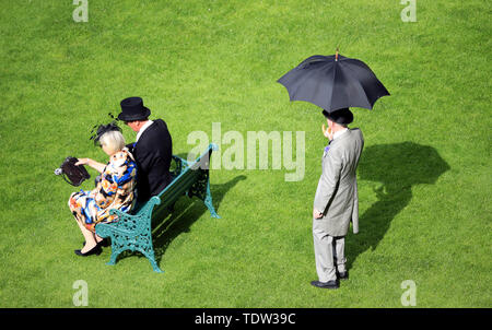 Racegoers Schutz vor dem Wetter unter Regenschirmen in Tag zwei des Royal Ascot Hotel in Ascot Pferderennbahn. Stockfoto