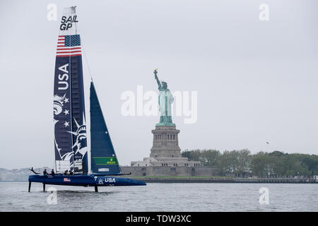 USA SailGP Team helmed durch Rom Kirby Segel an der Freiheitsstatue vorbei, die Schatten der Katamaran der Freiheitsstatue auf dem Flügel Segel, vor der Veranstaltung 3 Saison 1 SailGP Ereignis in New York City. Stockfoto