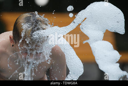 Berlin, Deutschland. Juni, 2019 19. Bei Temperaturen um die 33 Grad Celsius dieser Junge aktualisiert sich selbst in einem restaurierten Stadt Brunnen an der Karl-Marx-Alle. Quelle: Wolfgang Kumm/dpa/Alamy leben Nachrichten Stockfoto