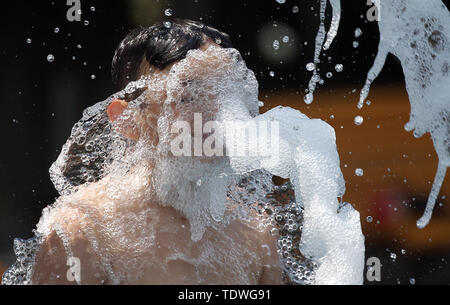Berlin, Deutschland. Juni, 2019 19. Bei Temperaturen um die 33 Grad Celsius dieser Junge aktualisiert sich selbst in einem restaurierten Stadt Brunnen an der Karl-Marx-Alle. Quelle: Wolfgang Kumm/dpa/Alamy leben Nachrichten Stockfoto