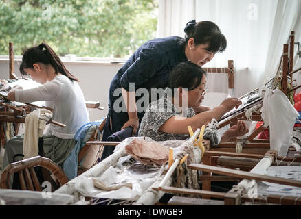 (190619) - NANJING, Juni 19, 2019 (Xinhua) - Yao Huifen führt Sie Lehrling bei Ihrer Werkstatt in Zhenhu Stadt Suzhou in der ostchinesischen Provinz Jiangsu, 11. Juni 2019. Suzhou Stickerei, einer der vier berühmtesten Stickereien in China, in Suzhou entstanden und hat eine Geschichte von mehr als 2.000 Jahren. Für die elegante Muster bekannt, künstlerische Gestaltung, feine Handarbeit und abwechslungsreiche Stiche, es war, als eine nationale Das immaterielle Kulturerbe Chinas im Jahr 2006 aufgeführt. Yao Huifen, repräsentatives Erbe der Fertigkeit, in Suzhou wurde 1967 in eine Familie von Stickerei geboren. Beeinflusst durch ihre Großeltern Stockfoto