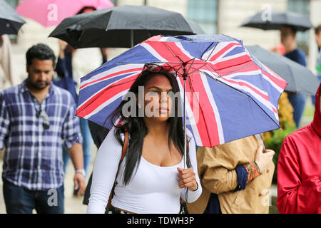 London, Großbritannien. Juni, 2019 18. Eine Frau, die Schutz vor dem Regen unter einer Union Jack Regenschirm während der schweren Regenguß in London Quelle: Dinendra Haria/SOPA Images/ZUMA Draht/Alamy leben Nachrichten Stockfoto