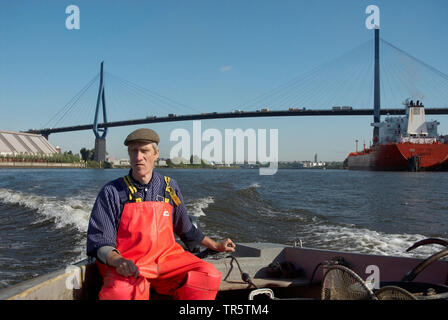 Fischerman in einem Fischerboot auf Elbe, koehlbrand Brücke im Hintergrund, Deutschland, Elbe, Hamburg Stockfoto