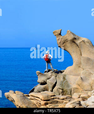 Wanderer auf einem Felsen an der Küste Tizzano im Süden von Korsika, Frankreich, Korsika Stockfoto