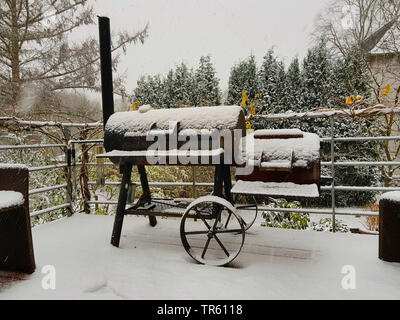 Barbecue-Smoker auf einer Terrasse im Garten im Winter, Deutschland Stockfoto