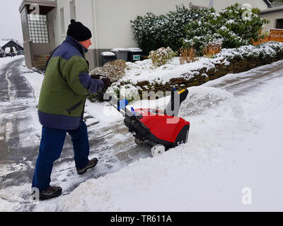 Mann mit snowblow Schnee entfernen aus einem Pflaster, Deutschland, Nordrhein-Westfalen, Ruhrgebiet, Witten Stockfoto