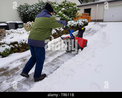 Mann mit snowblow Schnee entfernen aus einem Pflaster, Deutschland, Nordrhein-Westfalen, Ruhrgebiet, Witten Stockfoto
