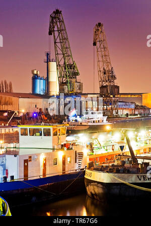 Frachtschiffe und Krane in den Binnenhafen Duisburg bei Nacht, Deutschland, Nordrhein-Westfalen, Ruhrgebiet, Duisburg Stockfoto