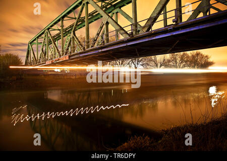 Das frachtschiff am Rhein-Herne-Kanal mit Brücke in der Nacht im Winter, Deutschland, Nordrhein-Westfalen, Ruhrgebiet, Herne Stockfoto
