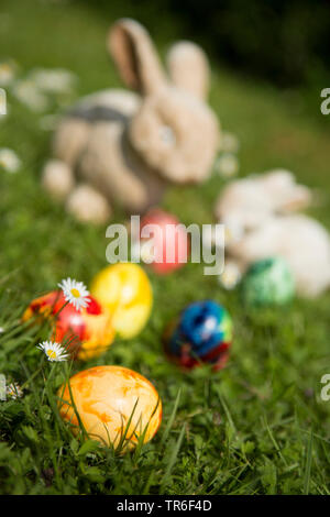 Osterhasen und Ostereier auf Rasen, Deutschland Stockfoto