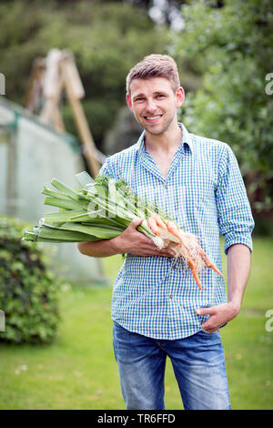 Junger Mann mit Gemüse aus dem eigenen Garten, Deutschland Stockfoto