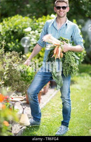 Junger Mann mit Gemüse aus dem eigenen Garten, Deutschland Stockfoto