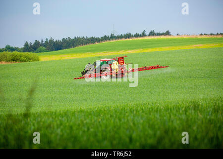 Weichweizen, Weizen (Triticum aestivum), Traktor Anwendung von Pestiziden auf ein Weizenfeld, Deutschland, Bayern