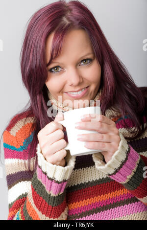 Junge, rothaarige Frau in Rollkragen-pullover mit Tasse Tee Stockfoto
