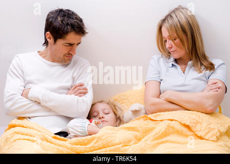 Tochter, die zwischen den Eltern im Bett schlafen Stockfoto