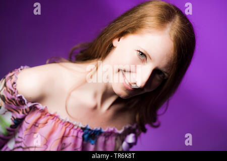 Lächelnde Frau vor der violette Hintergrund, Porträt Stockfoto