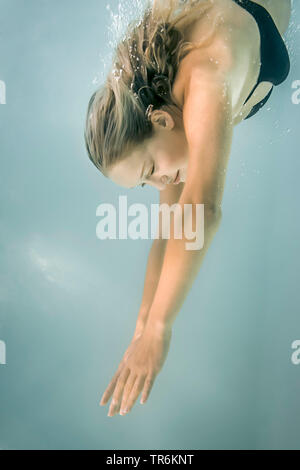 Junge blonde Frau, Tauchen im Schwimmbad, Deutschland Stockfoto