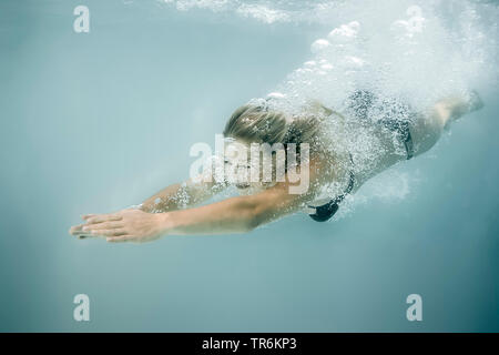 Junge blonde Frau, Tauchen im Schwimmbad, Deutschland Stockfoto