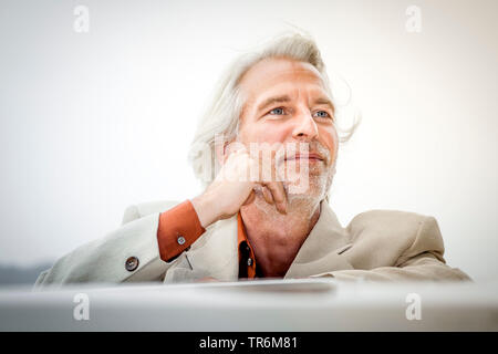 Senior lehnte sich an seinem Oldtimer Stockfoto