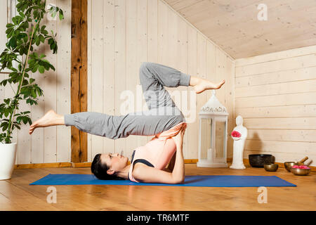 Frau Yoga auf eine Yogamatte in der Wohnung, Deutschland Stockfoto