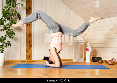 Frau Yoga auf eine Yoga Matte in der flachen, Kopfstand, Deutschland Stockfoto