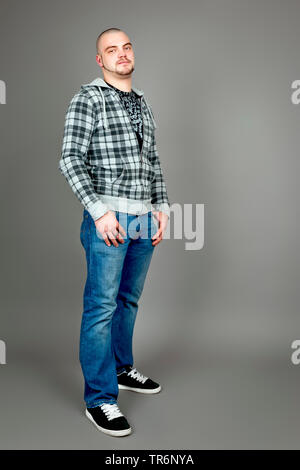 Junge glatzköpfige Mann in Weste eine Jeans an der Spitze, Deutschland Stockfoto