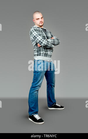 Junge glatzköpfige Mann in Weste eine Jeans an der Spitze, Deutschland Stockfoto