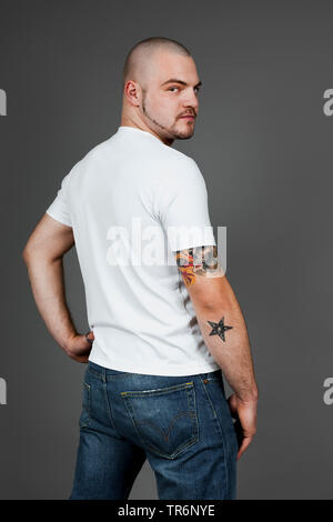 Jungen tätowierten Mann in T-Shirt und Jeans, Deutschland Stockfoto