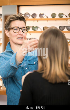 Optiker beraten, eine Frau in einem eyewear Store, Deutschland Stockfoto