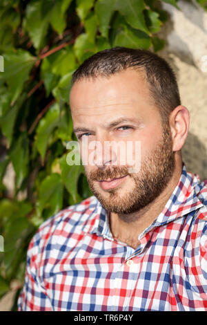 Porträt eines gutaussehenden Mann mit karierten Rock, Deutschland Stockfoto
