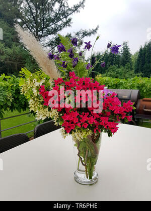 Blumenstrauß mit auf einem Schreibtisch auf eine Gartenterrasse, Deutschland Stockfoto