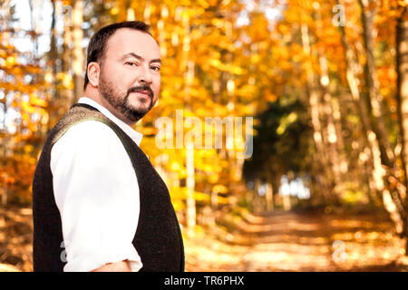 Mann in Bayerischen traditionelle Kleidung in einem Herbst Wald, Deutschland, Bayern Stockfoto